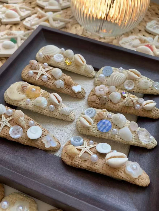 A pair of shell and straw hair clips